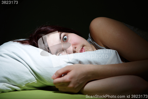 Image of Young woman in bed  eyes opened suffering insomnia. Nightmare issues