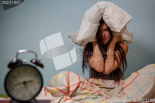 Image of Woman with a pillow over head.