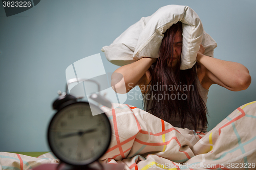 Image of Woman with a pillow over head.