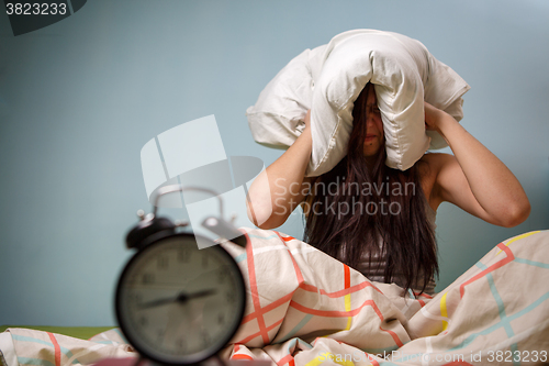 Image of Woman with a pillow over head.