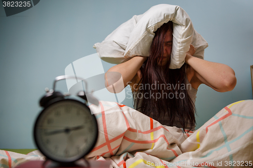 Image of Woman with a pillow over head.