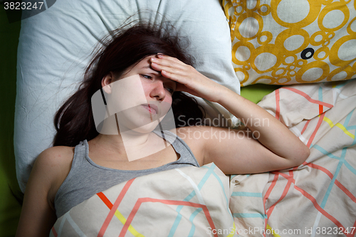 Image of Tired woman sleeping on a bed at home