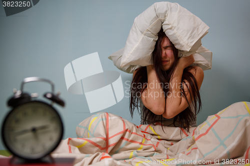 Image of Woman with a pillow over head.