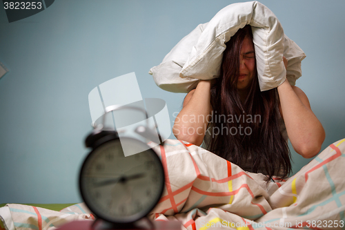 Image of Woman with a pillow over head.