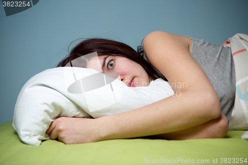 Image of Young woman in bed  eyes opened suffering insomnia. Nightmare issues