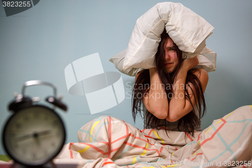 Image of Woman with a pillow over head.