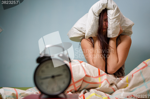 Image of Woman with a pillow over head.