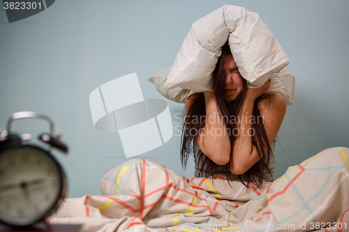 Image of Woman with a pillow over head.