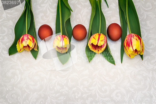 Image of Three Easter eggs and tulips.