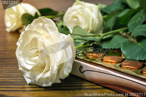 Image of White roses and chocolates as a gift.