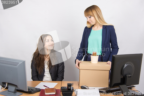 Image of Office worker with a smile looking at the dismissed colleague