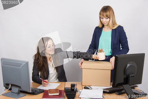 Image of Office employee happily helps collect things sacked colleague