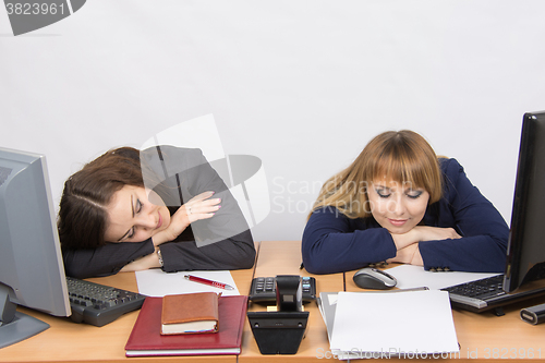 Image of Two young office worker sleeping on desk for computers