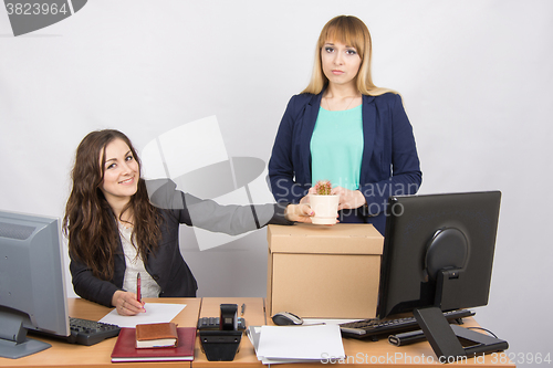 Image of Office worker happily helps collect things sacked colleague