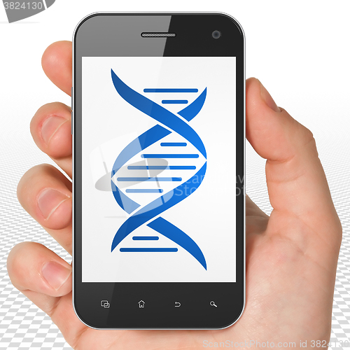 Image of Health concept: Hand Holding Smartphone with DNA on display