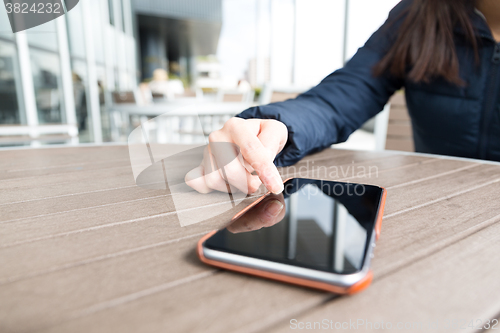 Image of Hands woman using her cell phone in restaurant