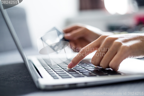 Image of Woman holding credit card on laptop for online shopping