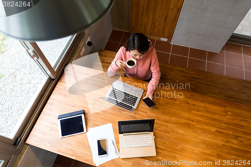 Image of Top view of woman drinking of coffee with checking the message o