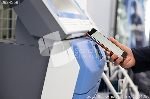 Image of Woman scanning discount coupon in ticketing machine