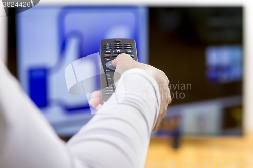 Image of Closeup on woman hand holding remote control