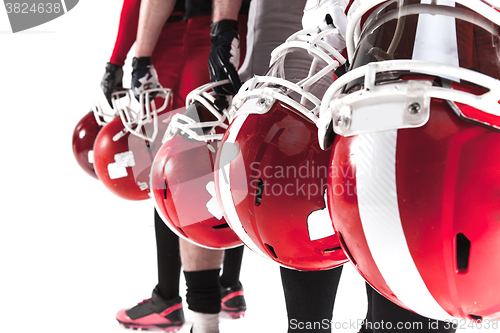 Image of The hands of american football players with helmets on white background