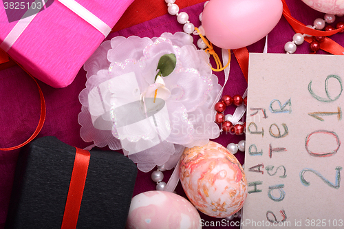 Image of Easter eggs and flowers on background with gift box