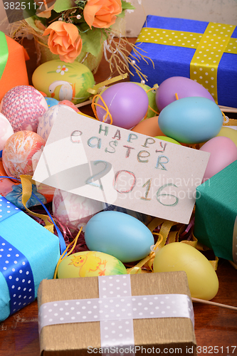 Image of Arrangement of Gift Boxes in Wrapping Paper with Checkered Ribbons and Decorated Easter Eggs isolated on white background