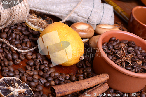 Image of orange and lemon, coffee beans and cinnamon on wooden brown background.