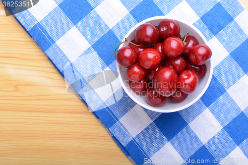 Image of Red ripe cherries in a white bowl