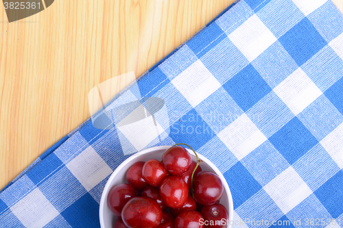 Image of Red ripe cherries in a white bowl