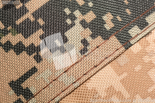 Image of close up of worn out olive green tone camouflage fabric