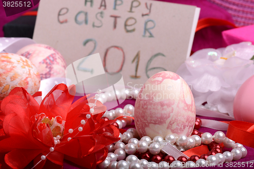 Image of Easter eggs and flowers on background with gift box