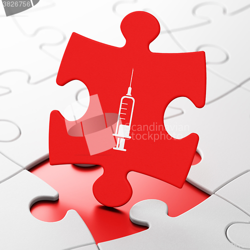 Image of Medicine concept: Syringe on puzzle background