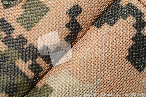 Image of close up of worn out olive green tone camouflage fabric