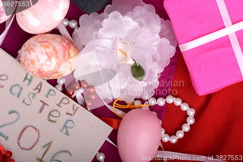 Image of Easter eggs and flowers on background with gift box