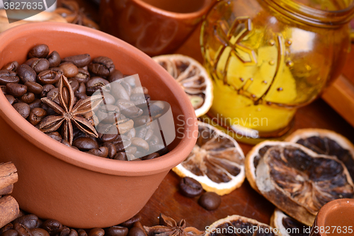 Image of orange and lemon, coffee beans and cinnamon on wooden brown background.