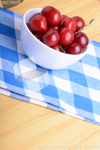 Image of Red ripe cherries in a white bowl