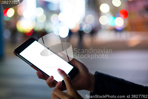 Image of Woman using cellphone at outdoor with defocused city traffic