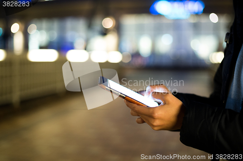 Image of Woman typing on cellphone at street