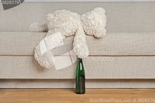 Image of Teddy bear is laying on the sofa