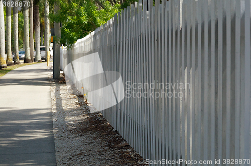 Image of white picket fence along sidewalk