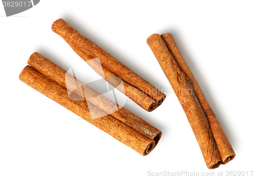 Image of Three cinnamon sticks lie nearby