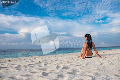 Image of Girl walking along a tropical beach in the Maldives.