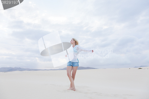 Image of Carefree woman enjoying freedom on beach.