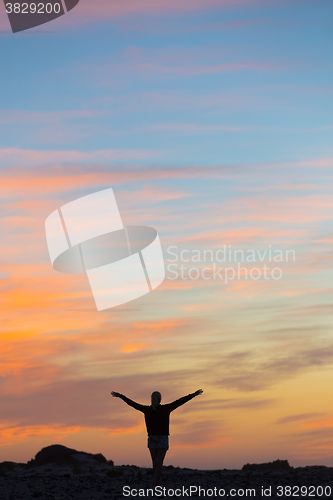 Image of Woman enjoying freedom at sunset.