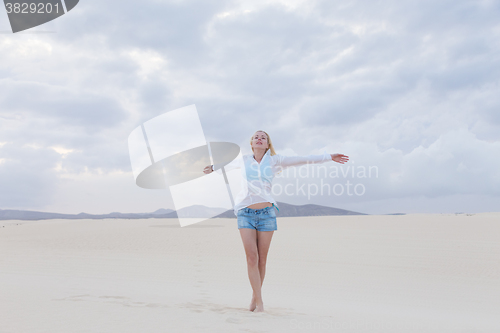 Image of Carefree woman enjoying freedom on beach.