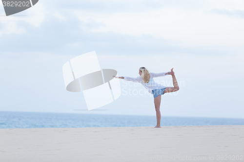 Image of Free woman streching on beach at down.