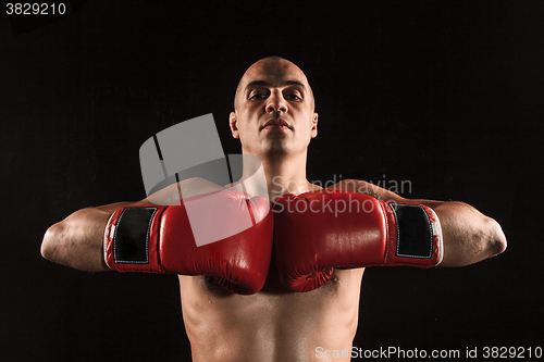 Image of The young man kickboxing on black