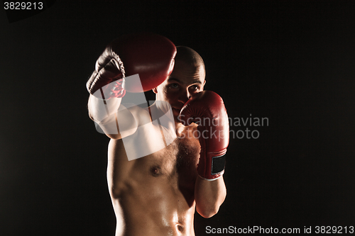 Image of The young man kickboxing on black