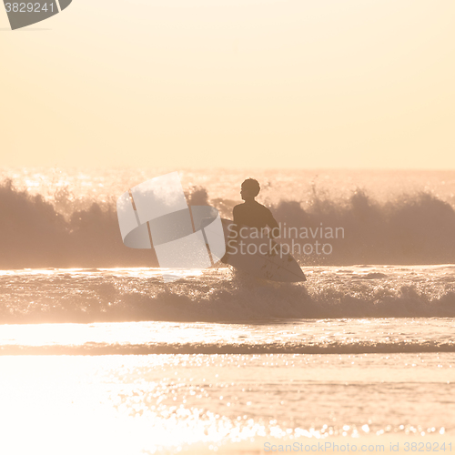 Image of Surfers on beach with surfboard.